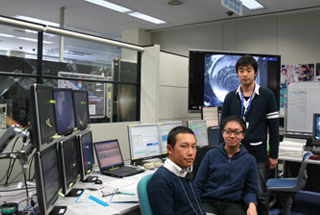 左から横浜国立大学の丑澤さん、札埜さん、矢野さん。「最初は粒子の流れの見方がわからなかった。でも先輩に教えてもらいながら繰り返すことで慣れてくる」。研究室で代々受け継がれて見る目が養われていく。JAXAつくば宇宙センター、実験運用管制室で。