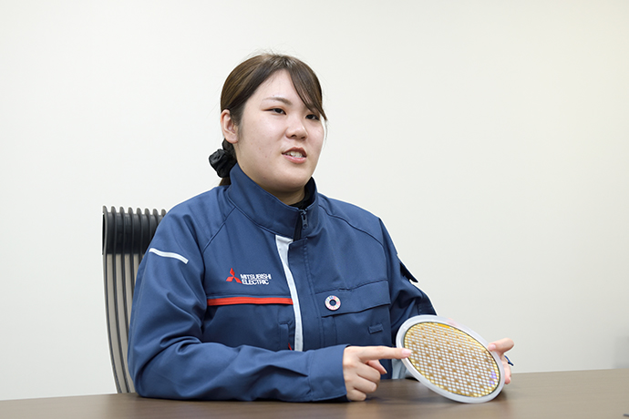 ウエハ※2に刻まれたSiCパワー半導体のチップを手に話す松岡さん