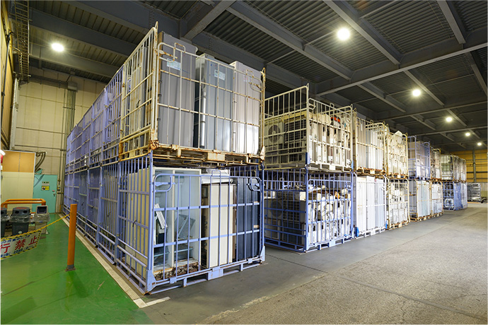 種類別に分けられた1日処理分の廃家電が整然と載せられリサイクルを待つコンテナの写真