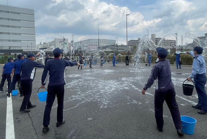 地区内の駐車スペースで一斉に打ち水を実施