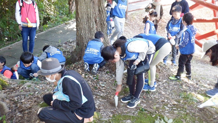 従業員とその子どもたちが交流しながら自然観察