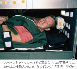 スペースシャトルのベットで寝袋に入った宇宙飛行士。頭の上の小物入れはまくらの代わり？（提供：NASA）
