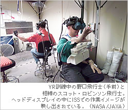 VR訓練中の野口飛行士（手前）と相棒のスコット・ロビンソン飛行士。ヘッドディスプレイの中にISSでの作業イメージが映し出されている。（NASA）