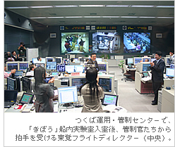 つくば運用・管制センターで、「きぼう」船内実験室入室後、管制官たちから拍手を受ける東覚フライトディレクター（中央）。