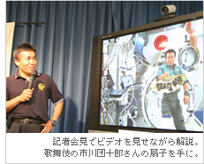 記者会見でビデオを見せながら解説。歌舞伎の市川団十郎さんの扇子を手に。