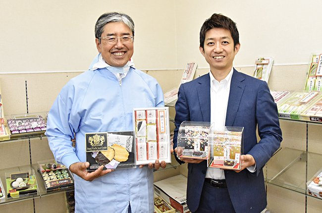 竹内製菓グループの製品を持つ清水氏（右）と荒井氏（左）
