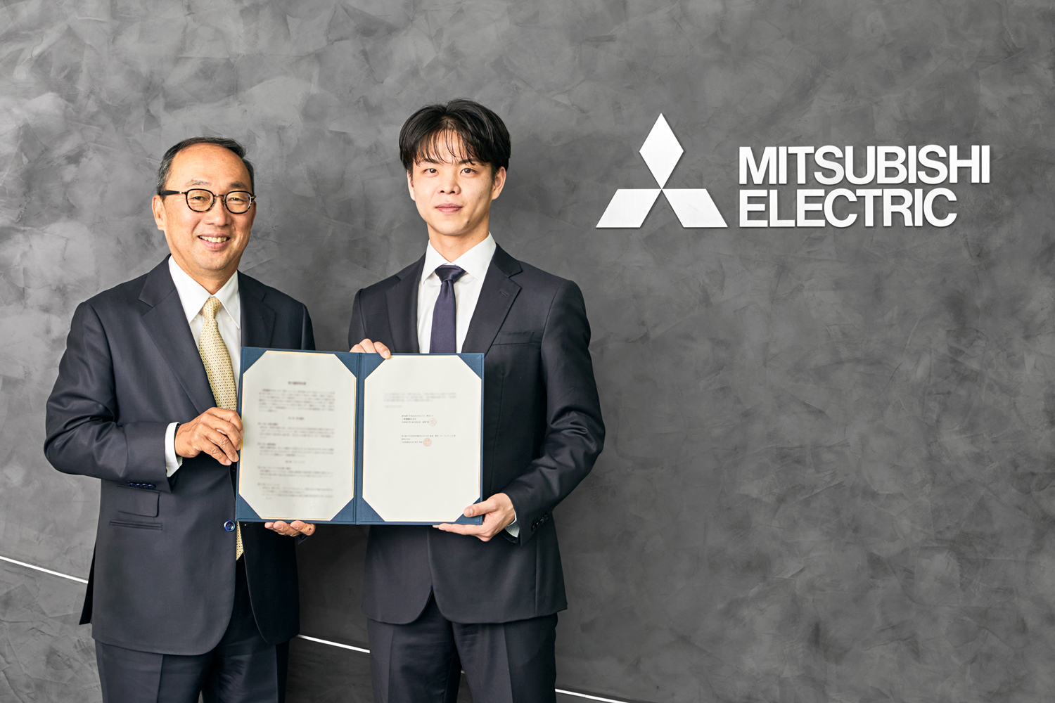 左から 三菱電機 執行役社長 漆間 啓、燈株式会社 代表取締役社長 野呂 侑希