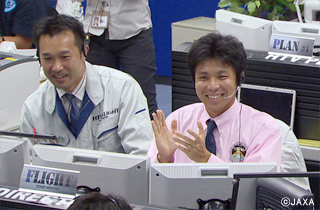 「こうのとり」3号機がミッションを完了し喜ぶ内山崇さん（右）。IHIから2008年JAXAに入社。2009年宇宙飛行士選抜試験ファイナリストに。その後「こうのとり」フライトディレクターに認定され、2012年の3号機でリードフライトディレクターを務める。2014年には「きぼう」フライトディレクターにも認定された。（提供：JAXＡ）