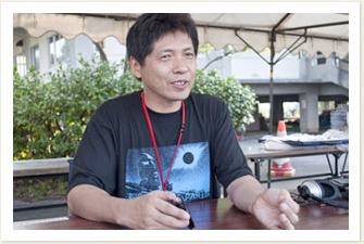 胎内星まつりのTシャツを着て取材に応じる沼澤さん。