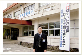 お話を伺った石堂さん。南種子役場には、H-IIBロケットの成功を祈願した垂れ幕が掲げられています。