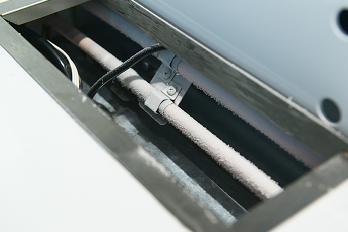 ショーケース下部にあるフロスト管。 積極的に空気中の水分を吸着させて霜をつけることで、冷却器やファンの着霜を抑制する